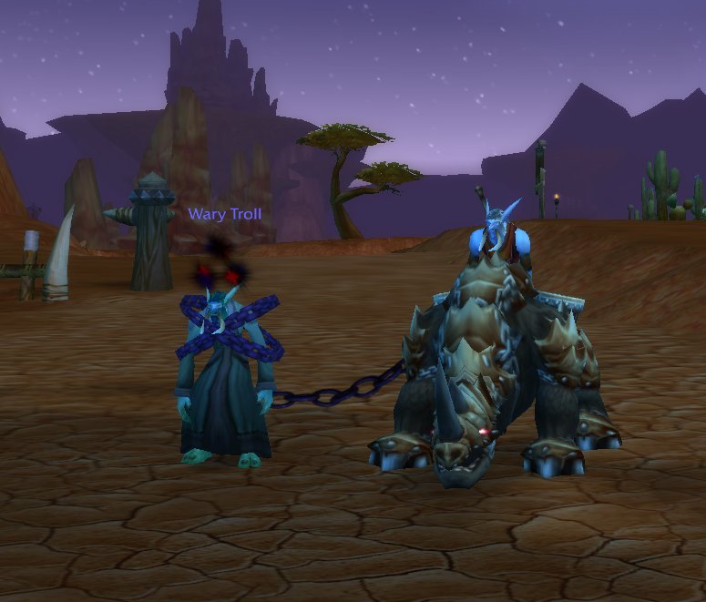 A troll in iron shackles, chained and led along a road at night.